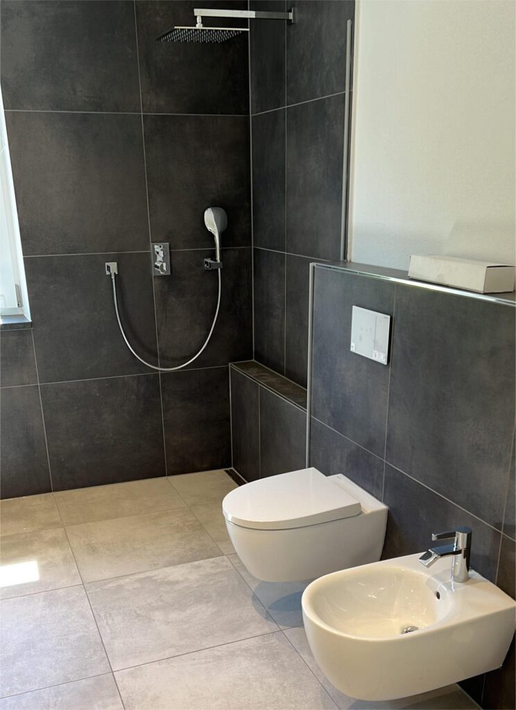 Modernes Bad mit dunklen und hellen Fliesen